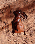 Lapin de Pâques en chocolat bio posé sur une fine couche de cacao en poudre. Son design facetté lui confère une allure moderne et élégante, sublimée par un jeu d’ombres et de lumières. Chocolat artisanal et gourmand, idéal pour célébrer Pâques